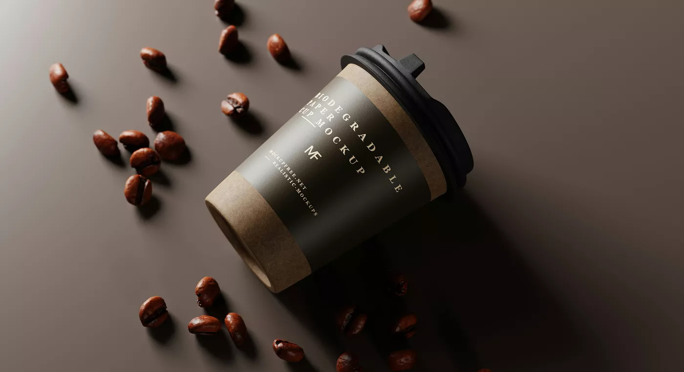Modern paper coffee cup mockup with kraft texture and white lettering, photographed with scattered roasted coffee beans