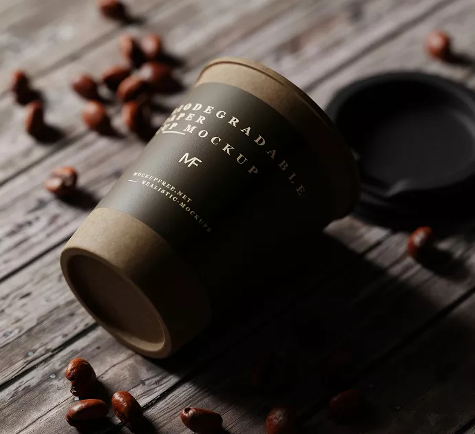 Premium eco-friendly coffee cup design featuring minimalist white text on textured brown paper sleeve with sustainable biodegradable materials